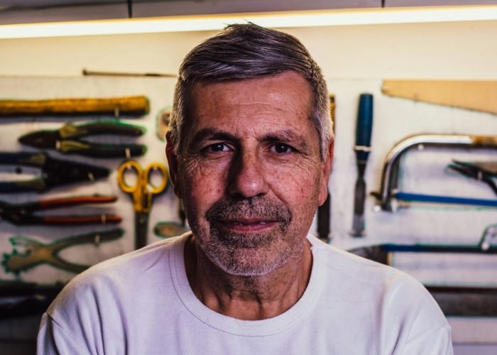 pexels-photo-1139743-1139743 Portrait of a senior man with tools in the background, exuding confidence.