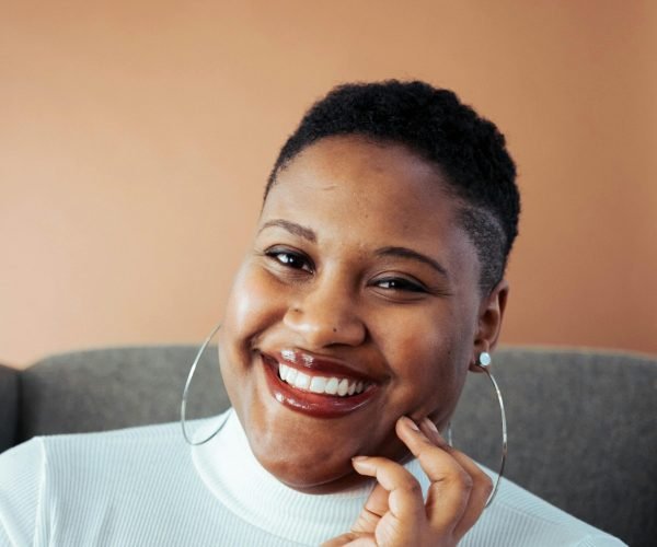 pexels-photo-3290236-3290236 Smiling woman in white turtleneck posing indoors with a joyful expression.